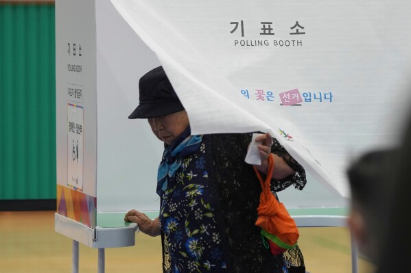 A woman exits a polling booth to cast her ballot for the presidential election at a polling station in Seoul, South Korea, Tuesday, June 3, 2025. (AP Photo/Lee Jin-man)