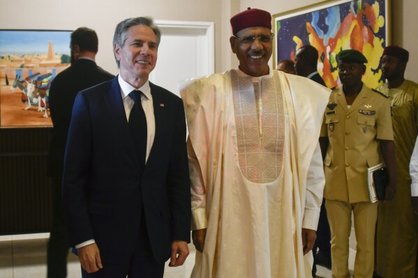 FILE- US Secretary of State Antony Blinken, left, poses for a photo with Nigerien President Mohamed Bazoum during their meeting at the presidential palace in Niamey, Niger, March 16, 2023. Bazoum said Wednesday July 26 2023 that elements of the presidential guard tried to move against him and that the army will attack if they don't back down. Streets surrounding the presidential palace in the capital Niamey were blocked off as were some of the ministries. (Boureima Hama/Pool Photo via AP/File)