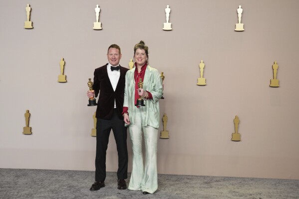 James Price, left, and Shona Heath pose in the press room with the award for best production design for "Poor Things"at the Oscars on Sunday, March 10, 2024, at the Dolby Theatre in Los Angeles. (Photo by Jordan Strauss/Invision/AP)