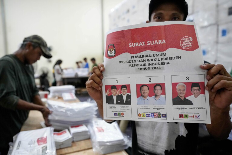 A worker displays ballots prepared for the upcoming presidential election at an election logistics distribution center in South Tangerang, Indonesia, Wednesday, January 10, 2024. Indonesia, the world's third-largest democracy, begins voting for its roughly 205 million voters on Wednesday. The turnout for presidential and parliamentary elections marks the fifth time since Southeast Asia's largest economy began democratic reforms in 1998.  (AP Photo/Tatan Shufrana)