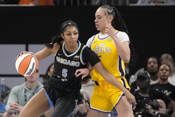 Chicago Sky's Angel Reese (5) drives to the basket as Los Angeles Sparks' Dearica Hamby defends during the first half of a WNBA basketball game Thursday, May 30, 2024, in Chicago. (AP Photo/Charles Rex Arbogast)