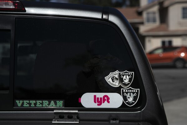Chris George's pickup truck displays a Lyft sticker on its back window outside a home where he works as a handyman, Saturday, Jan. 19, 2019, in Fontana, Calif. George, a 48-year-old US Army veteran and federal employee furloughed from his job as a forestry technician supervisor for the U.S. Department of Agriculture Forest Service, has been working as a handyman and driving for Lyft to make ends meet since the government shutdown began. (AP Photo/Jae C. Hong)