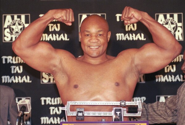 Heavyweight boxer George Foreman flexes his muscles after weighing in at 260 pounds for his upcoming fight against Shannon Briggs at the Trump Taj Mahal Casino Resort in Atlantic City., N.J., Thursday, Nov. 20, 1997. ((AP Photo/Charles Rex Arbogast, File)