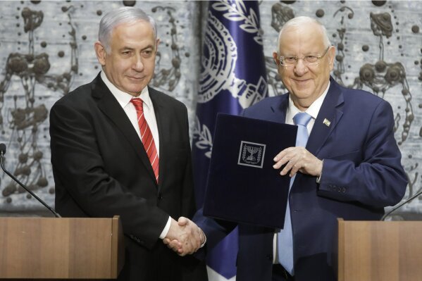 FILE - In this  Sept. 25, 2109 file photo, Israeli President Reuven Rivlin, right, shakes hands with Israeli Prime Minister Benjamin Netanyahu in Jerusalem. Rivlin said Monday, Oct. 21, 2019, that Prime Minister Benjamin Netanyahu has ended his quest to form a new coalition government -- a step that pushes the country into new political uncertainty. Netanyahu fell short of securing a 61-seat parliamentary majority in last month’s national election. (AP Photo/Sebastian Scheiner, File)