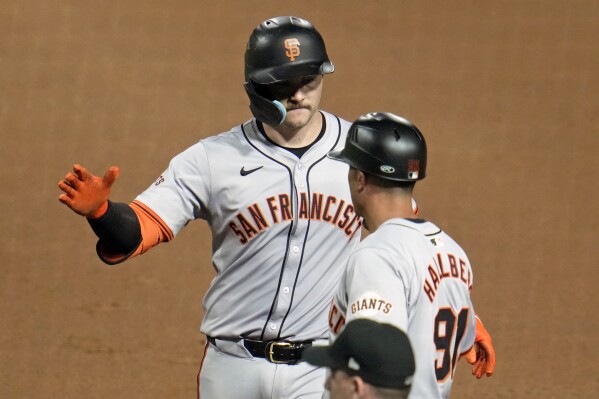 San Francisco Giants' Patrick Bailey, left, celebrates with first base coach Mark Hallberg after driving in the go-ahead run with a single off Pittsburgh Pirates relief pitcher Carmen Mlodzinski during the tenth inning of a baseball game in Pittsburgh, Wednesday, May 22, 2024. The Giants won 9-5 in ten innings. (AP Photo/Gene J. Puskar)