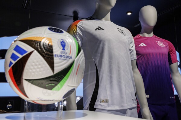 FILE - The official jerseys of the German national soccer team for the upcoming European Football Championship 2024 (UEFA EURO 2024) are on display at the headquarters of sporting goods manufacturer adidas AG, in Herzogenaurach, Germany, Thursday, March 14, 2024. The German soccer federation and Adidas have stopped the sale of Germany jerseys with the number 44 because of a resemblance to the logo of the Nazi party’s notorious SS paramilitary units. The federation says it's looking for an alternative design for the number 4 together with its partner. (Daniel Karmann/dpa via AP)