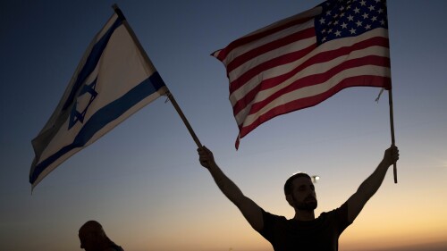 A man waves Israeli and U.S. flags during a protest against plans by Prime Minister Benjamin Netanyahu's new government to overhaul the judicial system, outside of the U.S. Embassy Branch Office in Tel Aviv, Israel on Thursday, July 13, 2023. (AP Photo/Maya Alleruzzo)