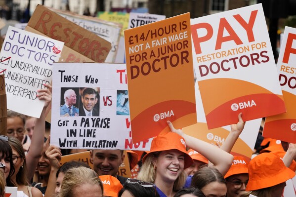 Demonstrators hold banners during a junior doctors rally outside Downing Street in London, Friday, Aug. 11, 2023. (AP Photo/Kirsty Wigglesworth, File)