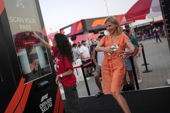 An F1 fan reacts after taking a selfie with Formula One drivers at an automated photo booth during the Formula One Bahrain Grand Prix Village at the Bahrain International Circuit in Sakhir, Bahrain, Friday, April 11, 2025. (AP Photo/Altaf Qadri)