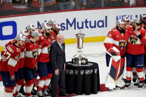 Bill Daly, deputy commissioner of the NHL, center left, poses with the Florida Panthers and the Prince of Wales Trophy after after the Panthers defeated the New York Rangers in Game 6 to win the Eastern Conference finals of the NHL hockey Stanley Cup playoffs Saturday, June 1, 2024, in Sunrise, Fla. (AP Photo/Lynne Sladky)