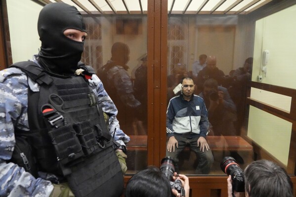FILE - Saidakrami Murodali Rachabalizoda, a suspect in the Crocus City Hall shooting, sits in a defendants’ cage in Basmanny District Court in Moscow, Russia, on March 24, 2024. The attack on the concert hall, the bloodiest assault on Russian soil in two decades, appears to be setting the stage for an increasingly harsh response by President Vladimir Putin. Four suspects in the attack appeared in court showing signs of brutal treatment while in custody. (AP Photo/Alexander Zemlianichenko, File)