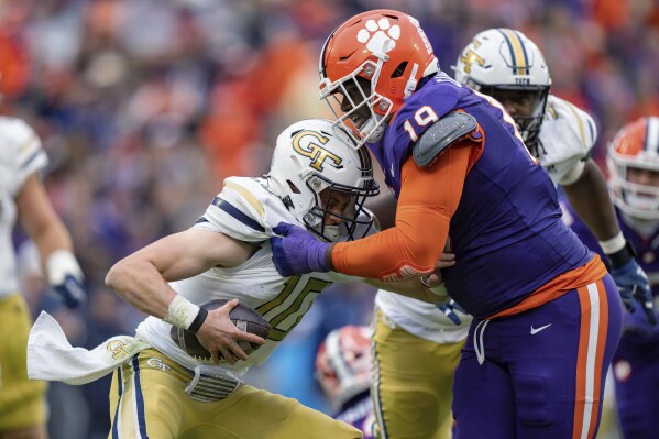 FILE - Clemson defensive tackle DeMonte Capehart (19) sacks Georgia Tech quarterback Haynes King (10) during the second half of an NCAA college football game Nov. 11, 2023, in Clemson, S.C. Capehart was arrested and charged with unlawful possession of a firearm on university property this month. Online records in Pickens County detail that Capehart was arrested Feb. 6. He also was charged with failure to exercise due care in a motor vehicle. (APPhoto/Jacob Kupferman, File)