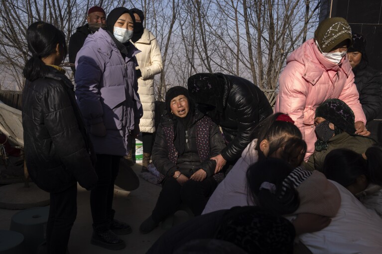 Family members grieve for Han Suofeiya who was killed in an earthquake in Yangwa village near Dahejia town in northwestern China's Gansu province, Wednesday, Dec. 20, 2023. (AP Photo/Ng Han Guan)