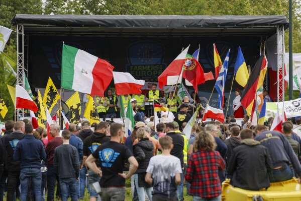 FILE - Farmers hold flags of European countries as they gather to listen leaders speeches during a protest in Brussels, June 4, 2024. The far right racked up wins across much of Europe in the EU Parliamentary elections that just concluded. Former President Donald Trump is trying to ride the same populist wave to return to the White House in November. But while the movements are propelled by similar forces, it's far from guaranteed the United States will follow Europe's example this year. (AP Photo/Omar Havana, File)