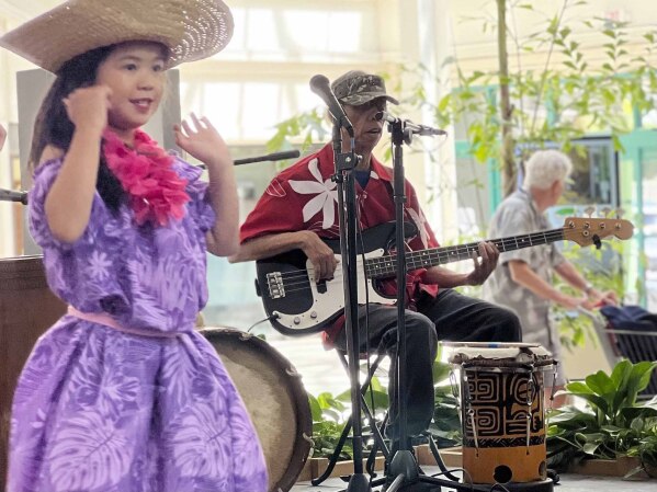 Buddy Jantoc, center, plays guitar at a hula show at the Lahaina Cannery in Lahaina, Hawaii, on April 23, 2023. (Agnes Dinh via AP)