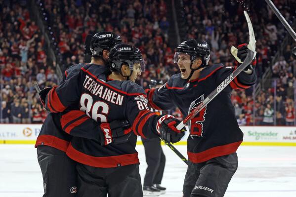Carolina Hurricanes' Teuvo Teravainen (86) celebrates his goal with teammates Brent Burns, and Martin Necas, right, during the second period of an NHL hockey game against the Dallas Stars in Raleigh, N.C., Saturday, Dec. 17, 2022. (AP Photo/Karl B DeBlaker)