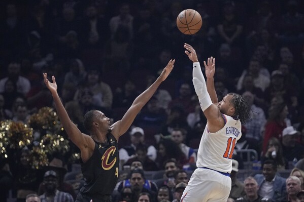 New York Knicks guard Jalen Brunson (11) shoots over Cleveland Cavaliers forward Evan Mobley (4) during the first half of an NBA basketball game Tuesday, Oct. 31, 2023, in Cleveland. (AP Photo/Sue Ogrocki)