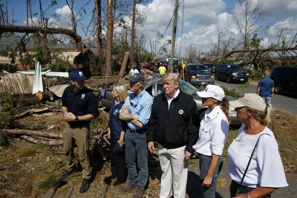 
              FEMA director Brock Long, left, talks with from left, Homeland Security Secretary Kirstjen Nielsen, Florida Gov. Rick Scott, President Donald Trump, first lady Melania Trump and Margo Anderson, Mayor of Lynn Haven, right, as they tour a neighborhood affected by Hurricane Michael, Monday, Oct. 15, 2018, in Lynn Haven, Fla. (AP Photo/Evan Vucci)
            