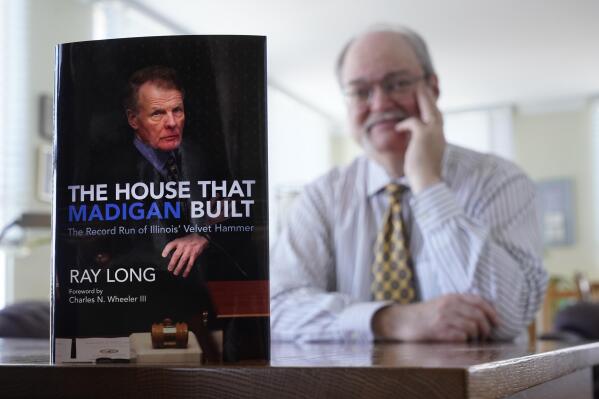 Chicago Tribune investigative reporter Ray Long poses for a portrait with his soon to be released book, The House That Madigan Built, at his Chicago home Tuesday, March 15, 2022. Long's account is not a biography of former Illinois House Speaker Michael Madigan, but a series of vignettes marking highs and lows of a remarkable political timeline. (AP Photo/Charles Rex Arbogast)