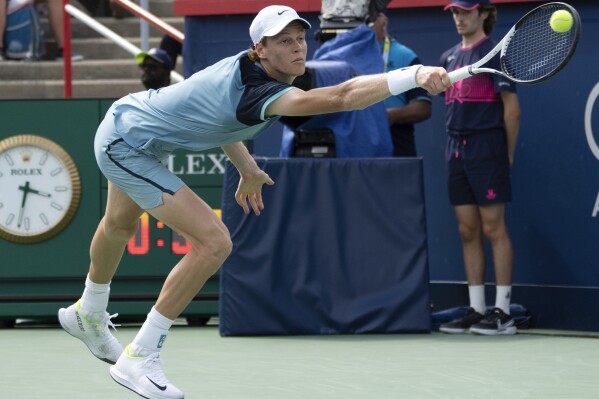 CORRECTS TO BORNA CORIC NOT BORJA CORIC - Italy's Jannik Sinner lunges for a shot from Croatia's Borna Coric during their second-round match at the National Bank Open tennis tournament Thursday, Aug. 8, 2024, in Montreal. (Ryan Remiorz/The Canadian Press via AP)