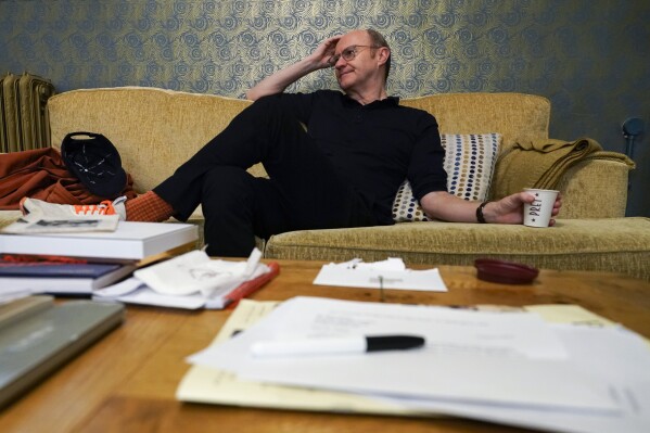 Mark Gatiss poses for a photo during an interview with The Associated Press at a theater, in London, Thursday, March 14, 2024. The turbulent union of actors Richard Burton and Elizabeth Taylor that set gossip columns aflame are the subjects of “The Motive and the Cue,” a play that is being broadcast in cinemas in Britain and internationally starting Thursday as part of the National Theatre Live series. The play looks at a famous 1964 production of “Hamlet” that starred Burton and was directed by John Gielgud. Mark Gatiss plays Gielgud in the witty and moving look at fame’s fickleness and cost. (AP Photo/Alberto Pezzali)