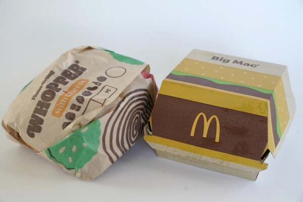 FILE - A Burger King Whopper in a wrapper, left, rests next to a McDonald's Big Mac in a container, in Walpole, Mass., Wednesday, April 20, 2022. Food wrappers and packaging that contain “forever chemicals” that can harm human health are no longer being sold in the U.S., the Food and Drug Administration announced Wednesday, Feb. 28, 2024. (AP Photo/Steven Senne, File)