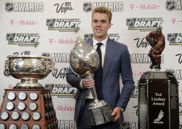 
              FILE - In this Wednesday, June 21, 2017 file photo, Connor McDavid of the Edmonton Oilers poses with the Art Ross Trophy, left, the Hart Memorial Trophy, center, and the Ted Lindsay Award after winning the honors during the NHL Awards in Las Vegas. Connor McDavid is the first player to shake off personal stats, awards and achievements and put the focus on his team in Edmonton. Yet there he is on the cover of a video game or in a commercial for a bank.
(AP Photo/John Locher, File)
            