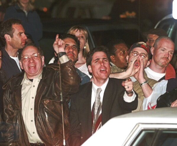 FILE - Crowd members react as OJ Simpson leaves Los Angeles County Superior Court, Tuesday, Feb. 4, 1997, in Santa Monica, Calif., after hearing the verdict in the civil wrongful death trial against OJ Simpson.  Football star and Hollywood actor Simpson, who was acquitted of charges of murdering his ex-wife and her friend but later found responsible in a separate civil trial, has died.  He was 76 years old.  (AP Photo/Susan Sterner, File)