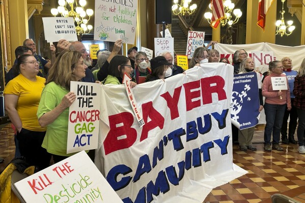 Protesters congregate at the Iowa state capitol building in Des Moines on Monday, Feb. 10, 2025, to rally against a bill that would protect pesticide companies from lawsuits that claim its popular weedkiller causes cancer. (AP Photo/Hannah Fingerhut)