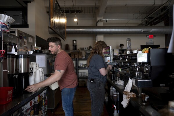 Anderson Miller, left, and Claire Terrelli, right, make coffee at Fuego Coffee Roasters in Rochester, N.Y., Saturday, March 22, 2025. (Max Conway via AP)