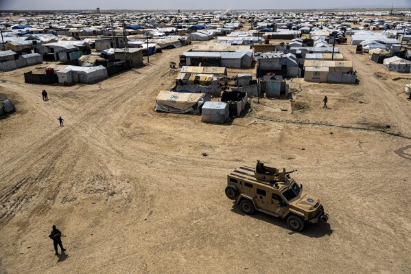 FILE - Kurdish forces patrol al-Hol camp, which houses families of members of the Islamic State group in Hasakeh province, Syria, on April 19, 2023. Kurdish-led authorities in northeast Syria handed over Thursday 50 family members of the Islamic State group fighters to a delegation from Tajikistan that escorted the repatriates back home. (AP Photo/Baderkhan Ahmad, File)