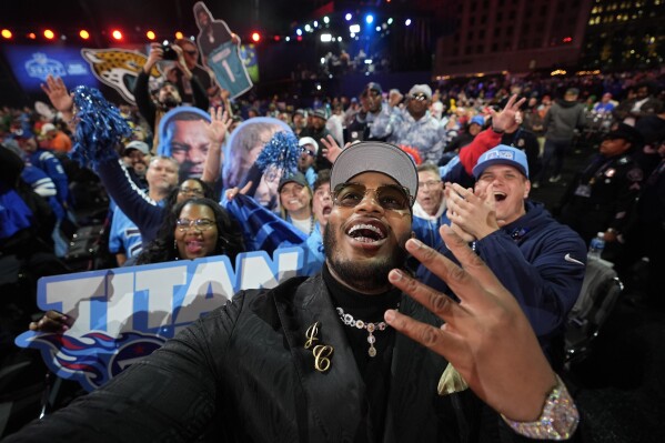 Alabama offensive lineman JC Latham celebrates with fans after being chosen by the Tennessee Titans with the seventh overall pick during the first round of the NFL football draft, Thursday, April 25, 2024, in Detroit. (AP Photo/Paul Sancya)