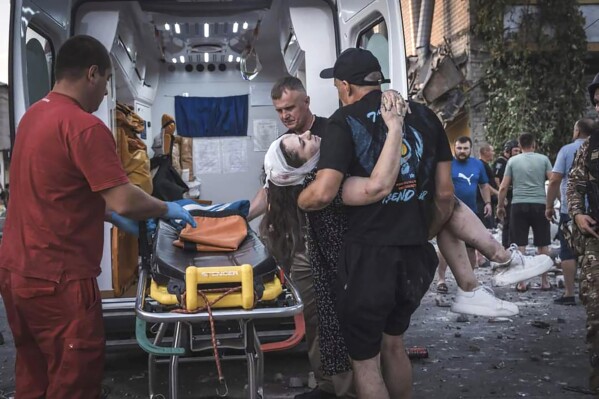 In this photo provided by the Ukrainian Emergency Service, people carry a wounded person from a damaged building after Russian missile strikes in Pokrovsk, Donetsk region, Ukraine, Monday, Aug. 7, 2023. (Ukrainian Emergency Service via AP Photo)