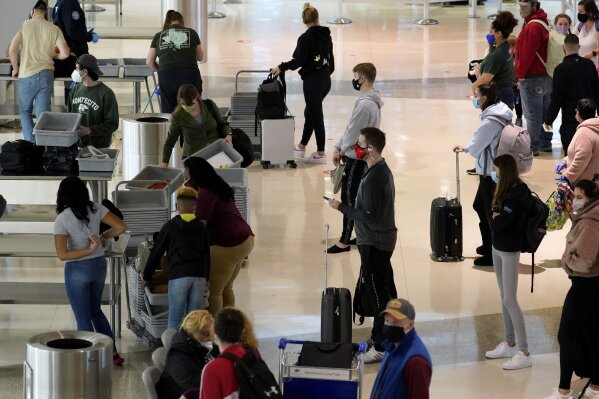 Air travelers line up to go through a a security checkpoint at Love Field Airport in Dallas, Tuesday, Nov. 24, 2020. (AP Photo/Tony Gutierrez)