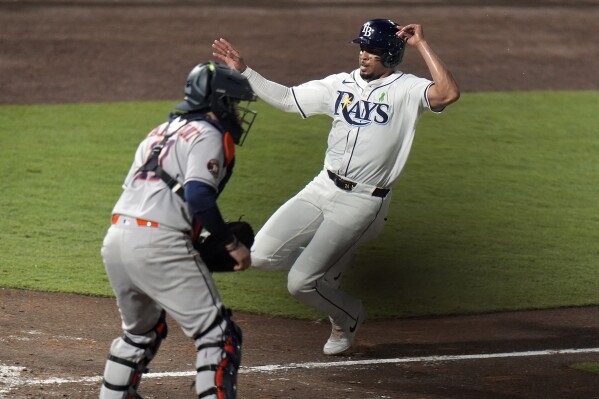 Tampa Bay Rays' Christopher Morel scores the game-winning run in front of Houston Astros catcher Victor Caratini on a sacrifice fly by Taylor Walls during the ninth inning of a baseball game Tuesday, May 20, 2025, in Tampa, Fla. (AP Photo/Chris O'Meara)