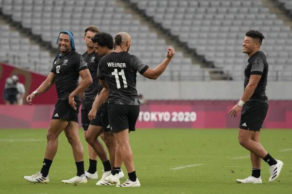 New Zealand players, including Sione Molia, left, celebrate as they walk off the pitch after defeating Argentina in men's rugby sevens match at the 2020 Summer Olympics, Monday, July 26, 2021 in Tokyo, Japan. (AP Photo/Shuji Kajiyama)