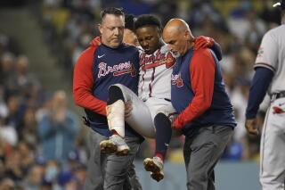 Atlanta Braves' Ozzie Albies is carried off the field after an injury during the fifth inning of the team's baseball game against the Los Angeles Dodgers on Tuesday, Aug. 31, 2021, in Los Angeles. (AP Photo/Marcio Jose Sanchez)