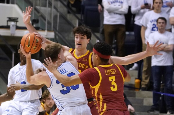 BYU guard Dallin Hall (30) is trapped by Iowa State forward Milan Momcilovic, rear, and guard Tamin Lipsey (3) during the first half of an NCAA college basketball game Tuesday, Jan. 16, 2024, in Provo, Utah. (AP Photo/George Frey)