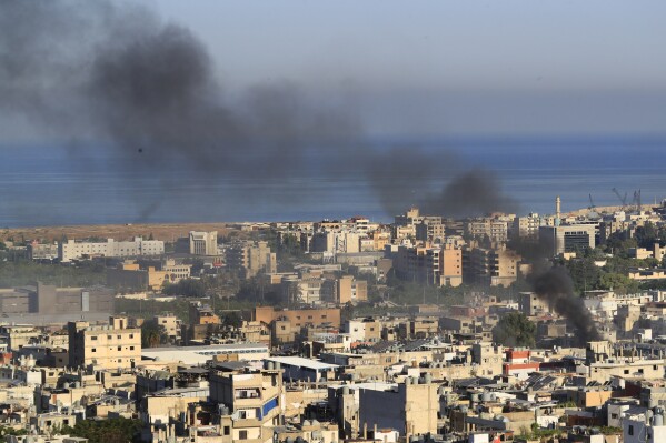 Smoke rises during clashes between members of the Palestinian Fatah group and Islamist militants in the Palestinian refugee camp of Ein el-Hilweh near the southern port city of Sidon, Friday, Sept. 8, 2023. Clashes resumed in Lebanon's largest Palestinian camp overnight, with heavy gunfire and shelling wounding several people and prompting residents of the camp and the surrounding area to flee Friday. (AP Photo/Mohammed Zaatari)