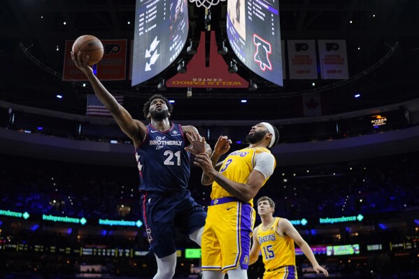 Philadelphia 76ers' Joel Embiid, left, goes up for a shot against Los Angeles Lakers' Anthony Davis during the first half of an NBA basketball game, Monday, Nov. 27, 2023, in Philadelphia. (AP Photo/Matt Slocum)
