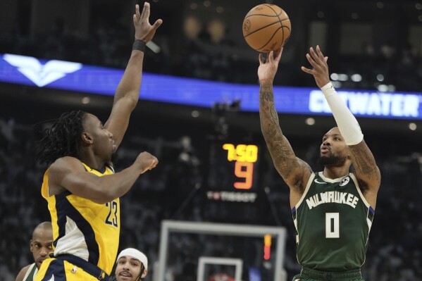 Milwaukee Bucks' Damian Lillard shoots past Indiana Pacers' Aaron Nesmith during the first half of Game 2 of the NBA playoff basketball game Tuesday, April 23, 2024, in Milwaukee. (AP Photo/Morry Gash)
