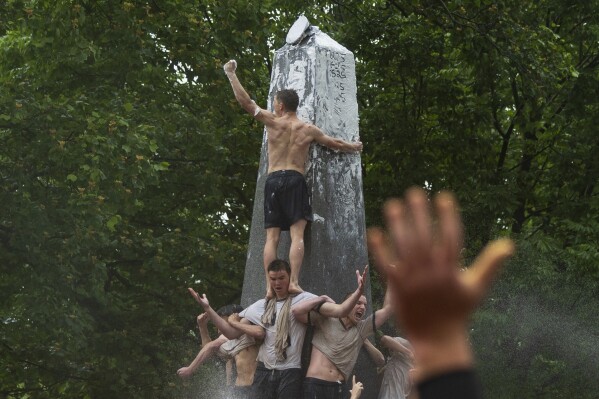 Plebe Ben Leisegang, of California, celebrates after successfully placing an upperclassman's hat atop the Herndon Monument at the U.S. Naval Academy, Wednesday, May 15, 2024, in Annapolis, Md. Freshmen, known as Plebes, participate in the climb to celebrate finishing their first year at the academy. The climb was completed in two hours, nineteen minutes and eleven seconds. (AP Photo/Tom Brenner)