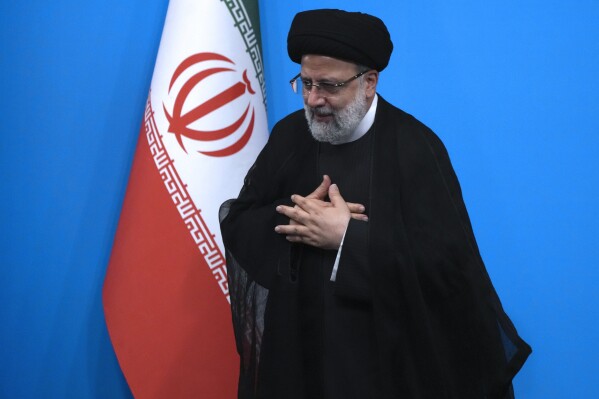 Iranian President Ebrahim Raisi places his hands on his heart as a gesture of respect as he leaves after a press conference in Tehran, Iran, Tuesday, Aug. 29, 2023. (AP Photo/Vahid Salemi)