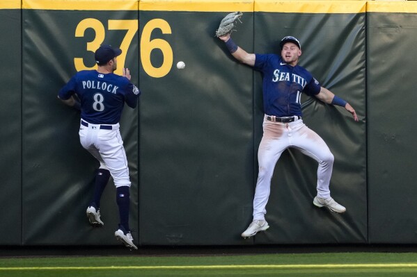 Seattle Mariners left fielder AJ Pollock (8) and center fielder Jarred Kelenic, right, can't come up with triple by Minnesota Twins' Alex Kirilloff during the fourth inning of a baseball game Tuesday, July 18, 2023, in Seattle. (AP Photo/Lindsey Wasson)