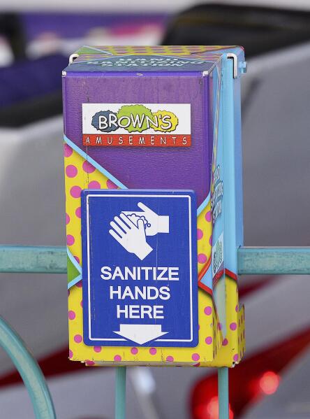 A new amenity on the carnival midway at the Yuma County Fair Fall Fest is hand sanitizer dispensers during the coronavirus pandemic, Friday, Oct. 15, 2021, in Yuma, Ariz. (Randy Hoeft/The Yuma Sun via AP)