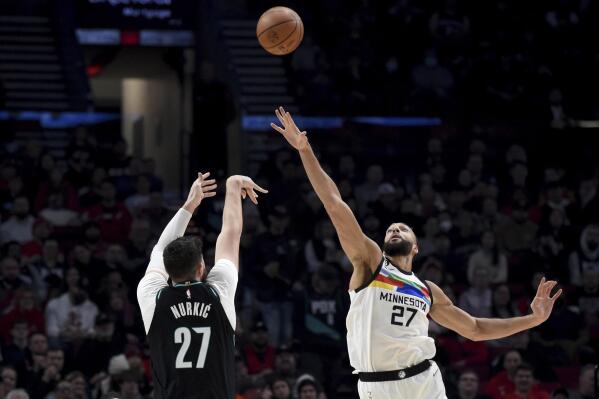 Portland Trail Blazers center Jusuf Nurkic, left, hits a shot over Minnesota Timberwolves center Rudy Gobert during the first half of an NBA basketball game in Portland, Ore., Saturday, Dec. 10, 2022. (AP Photo/Steve Dykes)