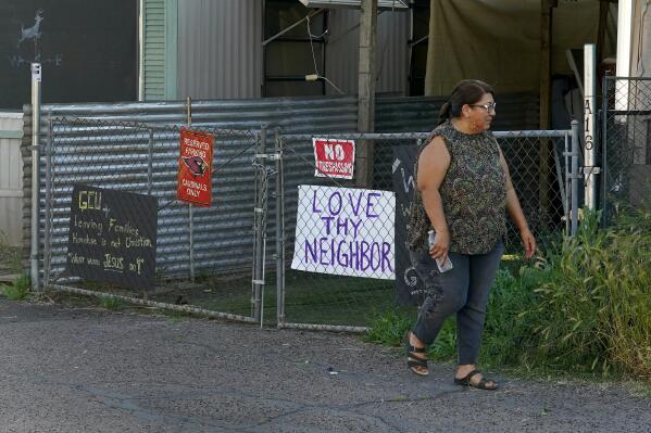 Alondra Ruiz Vazquez walks outside her home at the Periwinkle Mobile Home Park, Thursday, April 11, 2023, in Phoenix. Residents of the park are facing an eviction deadline of May 28 due to a private university's plan to redevelop the land for student housing. (AP Photo/Matt York)