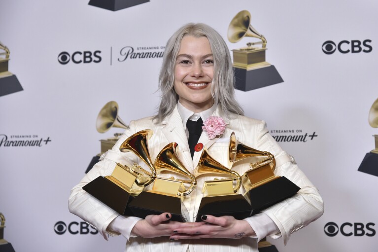 Phoebe Bridgers poses in the press room with the awards for best pop duo/group performance for 