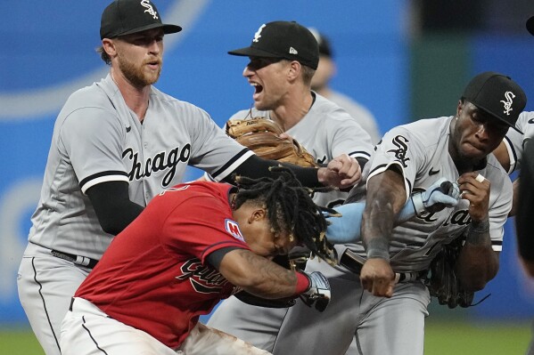 Chicago White Sox's Tim Anderson, right, punches Cleveland Guardians' Jose Ramírez, center, in the sixth inning of a baseball game Saturday, Aug. 5, 2023, in Cleveland. White Sox pitcher Michael Kopech, left, looks on. (AP Photo/Sue Ogrocki)