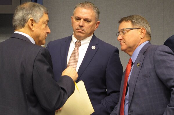 FILE - In a Feb. 7, 2020 file photo, Commissioner of Administration Jay Dardenne, the governor's chief budget adviser, left; House Speaker Clay Schexnayder, R-Gonzales, center; and Senate President Page Cortez, R-Lafayette, speak ahead of a meeting of Louisiana's income forecasting panel in Baton Rouge. Louisiana’s income forecasting panel planned to quantify on Monday, May 11, 2020 just how deeply the coronavirus outbreak has hurt the state’s economy as officials begin to put together next year’s budget.  (AP Photo/Melinda Deslatte, File)